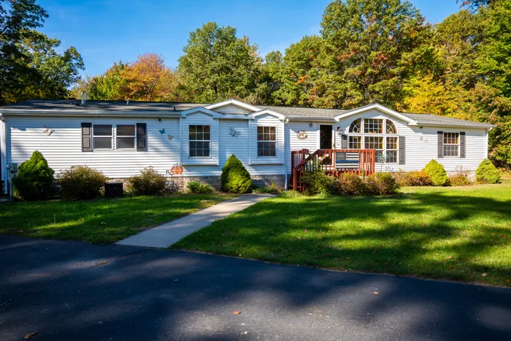 Home exterior with lawn and mature trees